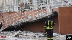 Mzima moto akisimama karibu na jengo la ghorofa lililoharibiwa na makombora ya Russia mjini Odesa, Ukraine, April 23, 2022. Picha ya AP
