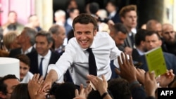 El presidente francés Emmanuel Macron, estrecha la mano de sus partidarios durante un mitin de campaña, en Figeac, sur de Francia, el 22 de abril de 2022.