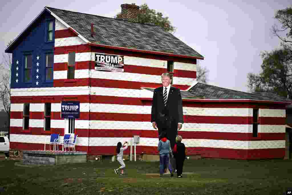 Seorang anak memotret foto raksasa Presiden-terpilih Donald Trump di depan rumah pendukung Trump di Youngstown, Pennsylvania.