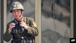 2013年4月4日，在南北双方边界的板门店非军事区，一名朝鲜士兵在观看对方韩国的情况。