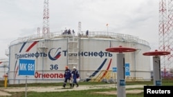 Wafanyakazi wakipita kwenye tenki la kuhifadhia mafuta la Kaleikino katika jimbo la Transneft, Russia, April 27, 2022. Picha ya Reuters