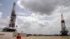 Un trabajador de un campo petrolero camina junto a las plataformas de perforación en un pozo petrolero operado por la petrolera estatal venezolana PDVSA, en la rica franja petrolera del Orinoco, el 16 de abril de 2015.