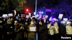 2022年11月28日，在中國北京，隨著新冠肺炎疫情的持續，人們在為烏魯木齊火災遇難者守夜後，手持白紙抗議新冠肺炎疫情限制措施。