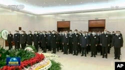 2022年12月5日，中国中央电视台播放的视频截图中，中国国家主席习近平和前任胡锦涛与其他领导人一起向前国家主席江泽民的遗体表示敬意。