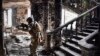 A Russian soldier patrols at the Mariupol drama theater that was bombed last March 16, in Mariupol, as Russian troops intensify a campaign to take the strategic port city, April 12, 2022.