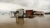 FILE - Vehicles are seen submerged in flood water at a petrol station in Lokoja, Nigeria, Oct. 13, 2022. 