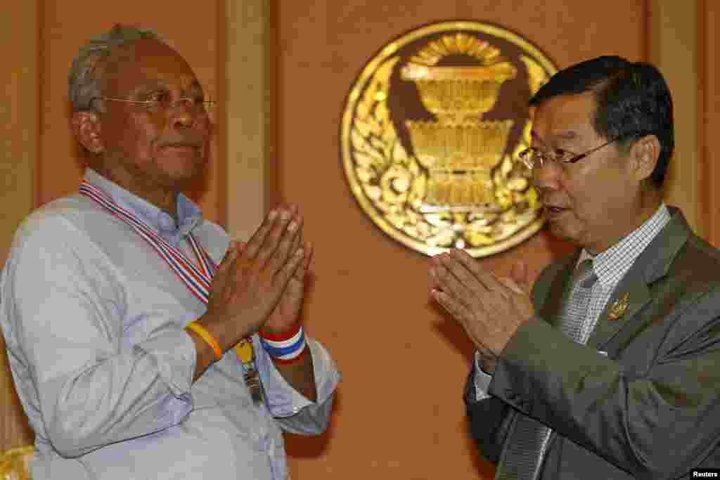 Ketua Senat yang baru dipilih Surachai Liengboonlertchai (kanan) dan pemimpin protes anti-pemerintah Suthep Thaugsuban saling menyapa di parlemen, Bangkok (12/5). (Reuters/Athit Perawongmetha)