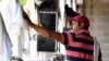 ARCHIVO - Kevin Contreras cuelga toallas y vendas en un granero en Louisville, Kentucky, el martes 18 de abril de 2017. Contreras, un trabajador inmigrante en EEUU con una visa H-2B es uno de los trabajadores de los que depende la industria de las carreras de caballos.