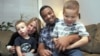 Damon Brown sits with his wife, Bethany, as they hold their sons Theo, 3, left, and Julian, 5, at their home in Seattle. Damon Brown found a kidney on Facebook after telling his story on a special page the Seattle dad created under the name, “Damon Kidney