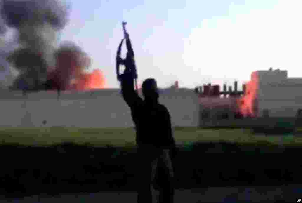 This image from video shows a building at the Syrian government checkpoint on fire in Dael, Syria, March 28, 2013.
