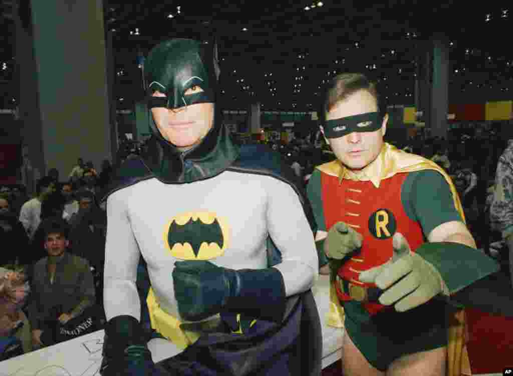 演员亚当·韦斯特( Adam West,左)和 Burt Ward, 装扮成蝙蝠侠和罗宾( Batman and Robin)参加车展(1989年) 。亚当·韦斯特在6月10日去世,他曾经在1960年代主演电视剧《蝙蝠侠》。这部连续剧支持了他的生涯,也限制了他的生涯。
