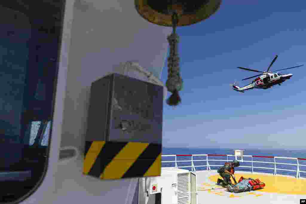A pregnant woman from Tunisia, whose pregnancy is at high risk, is prepared to be evacuated by an Italian coast guard helicopter from the Ocean Viking, a migrant search and rescue ship, off Italian coasts. Her husband, daughter, 7, and son, 2, were left behind on the ship. Some 459 migrants have been waiting eight days for the Italian government to allocate a port to disembark.