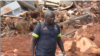 A South African police officer guides his sniffer dog in Ngangu, one of the areas hardest hit by Cyclone Idai in Chimanimani district, Zimbabwe, March 28, 2019.