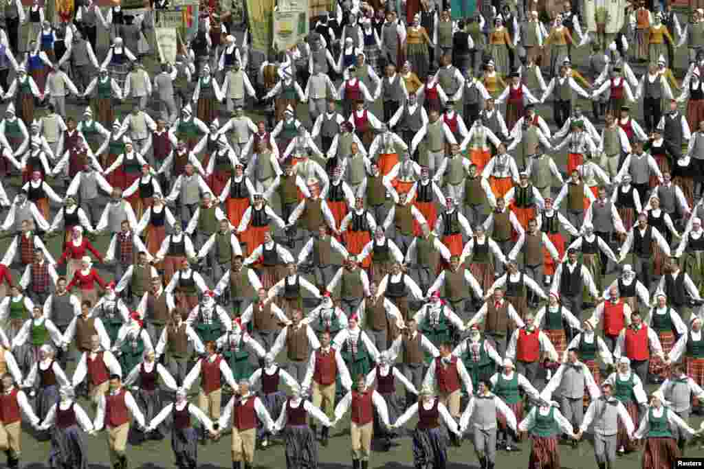 Ribuan penari dengan mengenakan kostum tradisional tampil dalam pertunjukan tari tradisional di kota Riga, Latvia. Tahun ini acara yang diadakan setiap 5 tahun sekali sejak tahun 1873 diikuti oleh sedikitnya 12 ribu penari dan penyanyi dari seluruh Latvia.