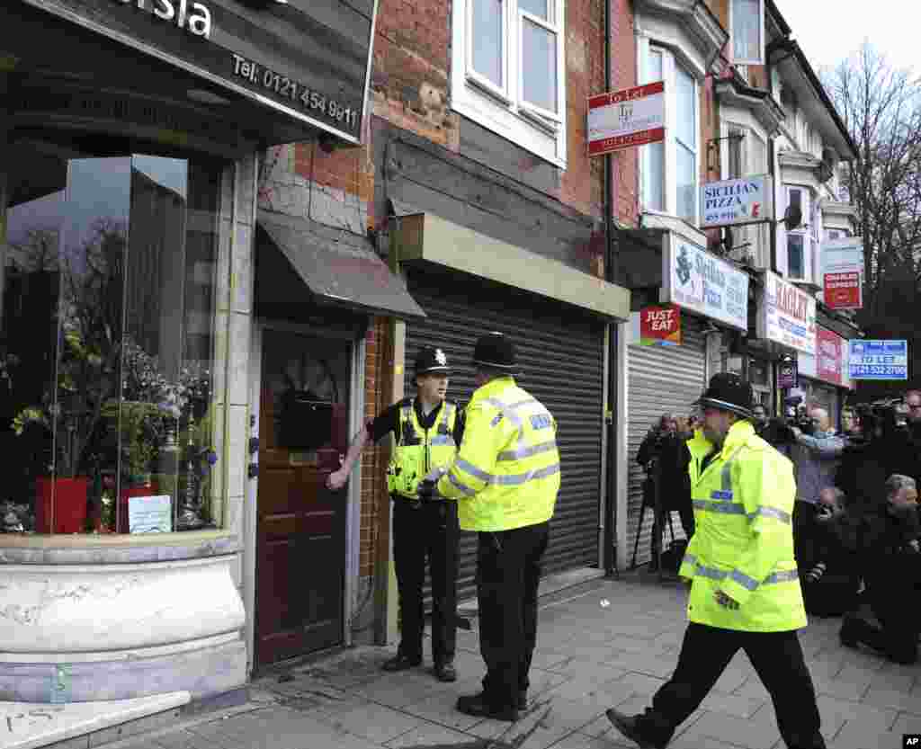 警方在英国伯明翰地区搜查,警察旁边的店铺招牌上有“波斯风味” 字样(2017年3月23日)。 英国警方已经逮捕了至少9人。随着调查的深入进行,预计还会有更多人被捕。