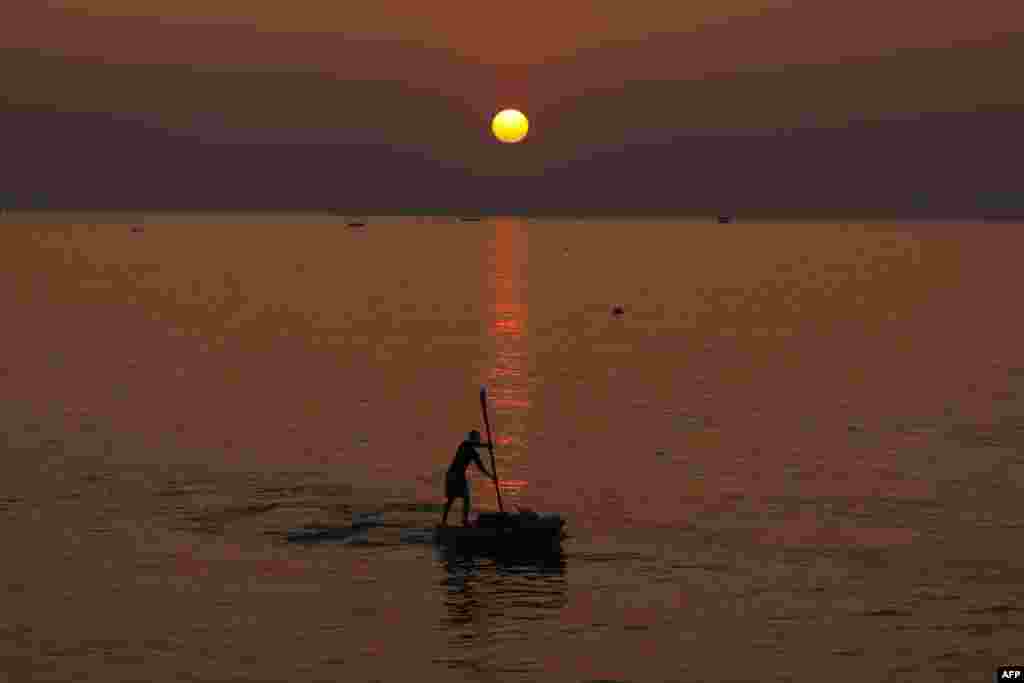A Palestinian man rows a boat at sunset off the coast of Gaza City.