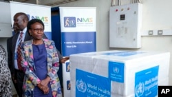 Waziri wa Afya wa Uganda Jane Ruth Aceng akipokea masanduku ya chanjo ya Ebola ya aina ya virusi vya Sudan, Entebbe, Uganda, Dec. 8, 2022. 