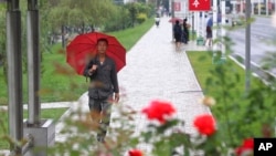 9月14日，一場降雨之後，人們在北韓鮮首都平壤中心地區走路。