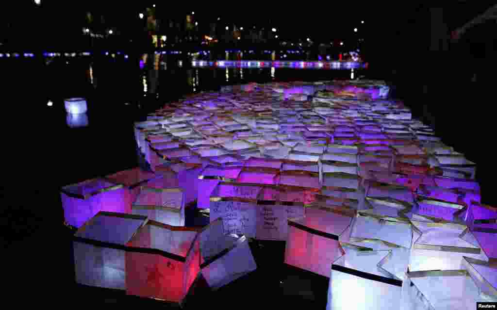 Warga Perancis melepas semacam 'lentera kertas' dengan lilin di Canal Saint-Martin di Paris, untuk memperingati setahun serangan teror yang menewaskan 130 orang.