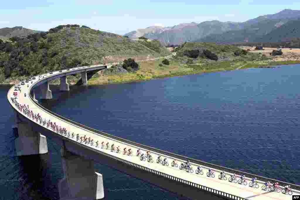 Para pebalap sepeda melewati waduk Twitchell pada etape ke-3 AMGEN Tour of California di kota Morro Bay, California.