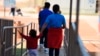 FILE - An Aug. 9, 2018, photo, provided by U.S. Immigration and Customs Enforcement, shows a woman and child walking at a Family Residential Center in Dilley, Texas. A mother and daughter deported to El Salvador were returned to a facility in Dilley late Thursday on orders of a U.S. judge. 