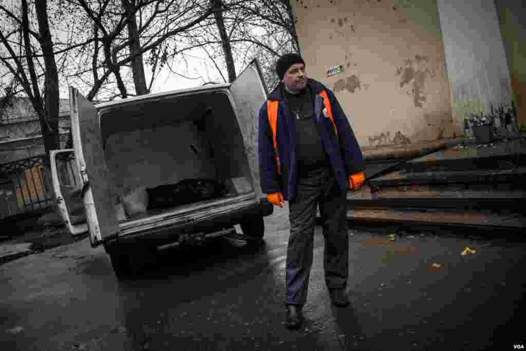 The Ukraine volunteer "body collector" places the corpse of a pro-Russian rebel in an ambulance. The volunteers regularly cross front lines to collect the bodies of the fallen, inside Donetsk People's Republic. (Adam Bailes/VOA)