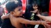 Rohingya minority children held by women board a bus after they were rescued by Thai authorities in Songkhla province, southern Thailand, Jan. 11, 2013.