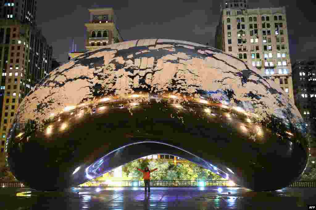 Salju tampak menutupi monumen "The Bean" di taman Milennium di kota Chicago, negara bagian Illinois, AS.