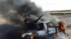 A pro-Moammar Gadhafi anti-aircraft machine gun is burned by Libyan rebels during a battle, in the town of Brega, east of Libya, March 2, 2011 