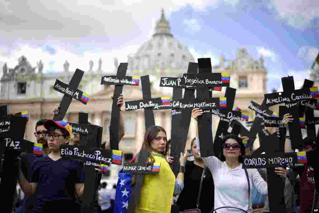 Para demonstran di Vatikan membawa salib hitam yang ditulisi nama korban dan dihiasi bendera Venezuela, untuk mengenang para demonstran anti pemerintah yang tewas dalam bentrokan dengan pasukan pemerintah di Caracas, Venezuela.