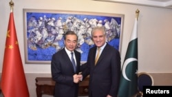 中国国务委员兼外交部长王毅在与巴基斯坦外长沙赫·穆罕默德·库雷希在伊斯兰堡握手（2018年9月8日）