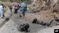 Para petugas kepolisian memeriksa lokasi bom bunuh diri di jalan raya di Shangla, sebuah distrik di Provinsi Khyber Pakhtunkhwa, Selasa, 26 Maret 2024. (Foto: AP Photo)