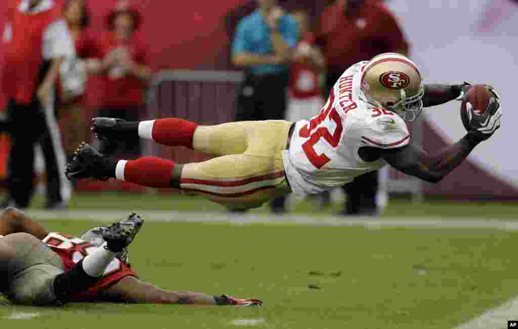 San Francisco 49ers' Kendall Hunter (32) dives into the end zone to score after picking up a fumble by Tampa Bay Buccaneers' Russell Shepard during the fourth quarter of an NFL football game in Tampa, Florida, USA, Dec. 15, 2013.