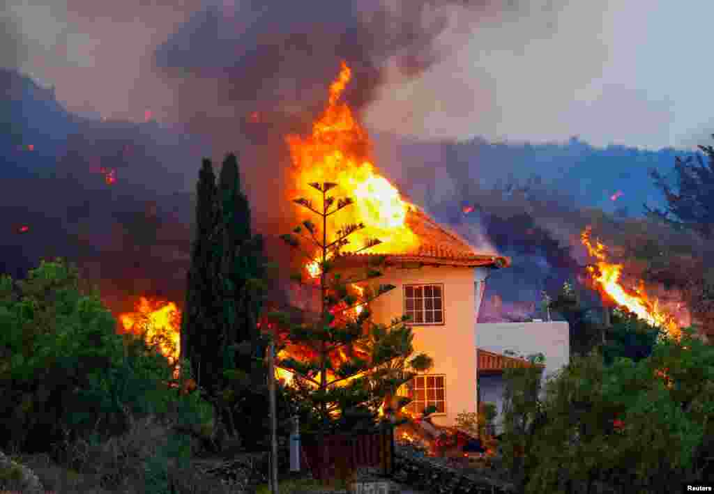 Lava flowing from an eruption of a volcano destroys a house in the Cumbre Vieja national park at Los Llanos de Aridane, on the Canary Island of La Palma, Spain. 