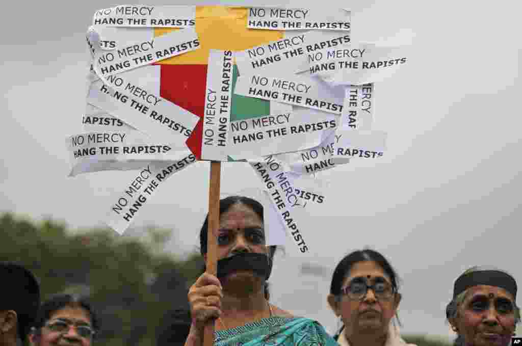 An Indian woman holds a placard as she joins others in a protest to mourn the death of the 23-year-old gang rape victim, in Bangalore, Saturday, Dec. 29, 2012.