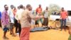 People stand near a body at the scene where a blast killed Kenyan police officers at the Garissa county, eastern Kenya, May 24, 2017. 