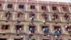 FILE - Indians climb the wall of a building to help students appearing in an examination in Hajipur, in the eastern Indian state of Bihar, March 18, 2014.