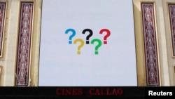 Question marks in the arrangement of Olympic rings are pictured on a screen at Madrid's landmark Callao Square, Sept. 6, 2013.