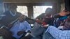 FILE - Protesters are beaten with wooden clubs inside the back of a police pickup truck after being arrested outside the Parliament building in Nairobi, Kenya, in December 2014.