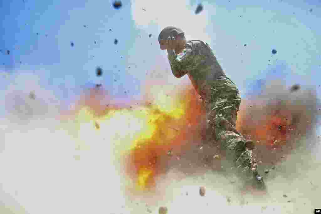 Gambar yang dirilis oleh Angkatan Darat AS. ini menunjukkan seorang tentara Afghanistan terbakar api saat sebuah tabung mortir meledak ketika tentara Angkatan Darat Afghanistan sedang melakukan latihan pemadam kebakaran di Provinsi Laghman. Fotografer pasukan tempur Angkatan Darat AS Spc. Hilda Clayton mengambil foto ini pada tanggal 2 Juli 2013. Kecelakaan tersebut menewaskan Clayton dan empat tentara Tentara Nasional Afghanistan.