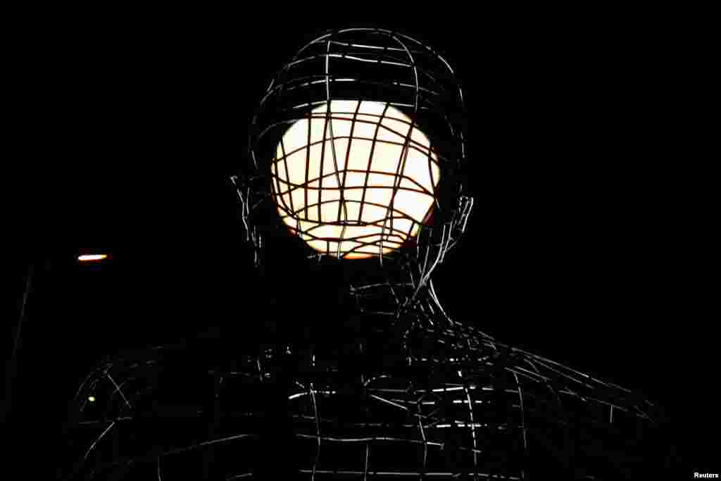Supermoon tampak di belakang patung "El Pensador" (The Thinker) di Dos Hermanas, dekat Sevilla, Spanyol.
