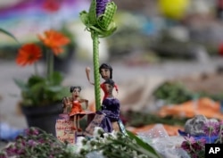 Figuras de mujeres con una leyenda que dice: "Unidas en solidaridad y fuertes" son parte de una ofrenda en una fábrica textil que se derrumbó la semana pasada en el terremoto de 7,1 que estremeció a México. Sept. 25, 2017.