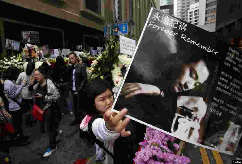 Seorang penggemar membawa potret mendiang aktor dan penyanyi Hong Kong, Leslie Cheung di luar hotel Mandarin Oriental Hotel dalam peringatan 10 tahun kematiannya.