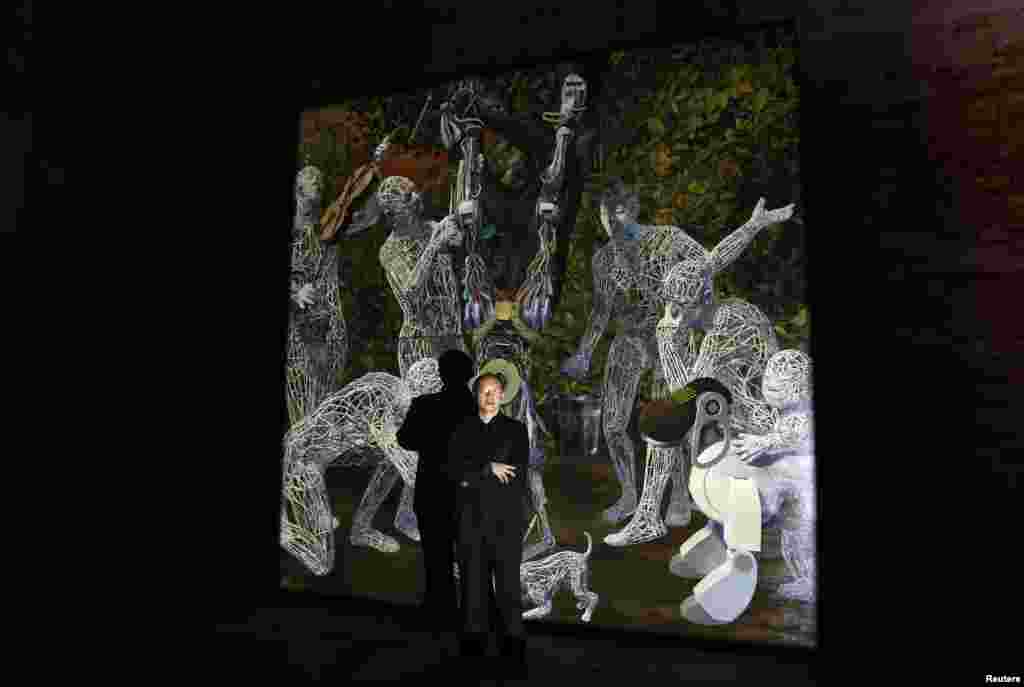 Seniman China Miao Xiaochun berpose dekat karya instalasi seninya yang berjudul "Transfiguration". (Reuters/Stefano Rellandini)