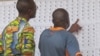 Des électeurs cherchent leurs noms avant d'aller voter dans un bureau à Yaoundé, Cameroun, le 30 septembre 2013.