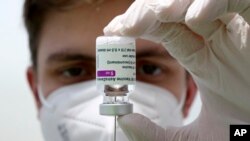 Staf medis menyiapkan jarum suntik dari botol vaksin virus corona AstraZeneca di Ebersberg dekat Munich, Jerman, 22 Maret 2021. (Foto: AP)