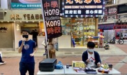Michael(左)认同家长为了子女有更好学习及成长环境带同子女移民，不需要被国安法“维稳教材”洗脑。（美国之音 / 汤惠芸）