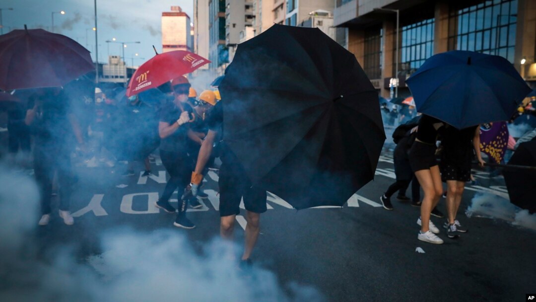 Učesnici protesta u Hong Kongu "brane" se kišobranima od suzavca, 28. jul 2019.