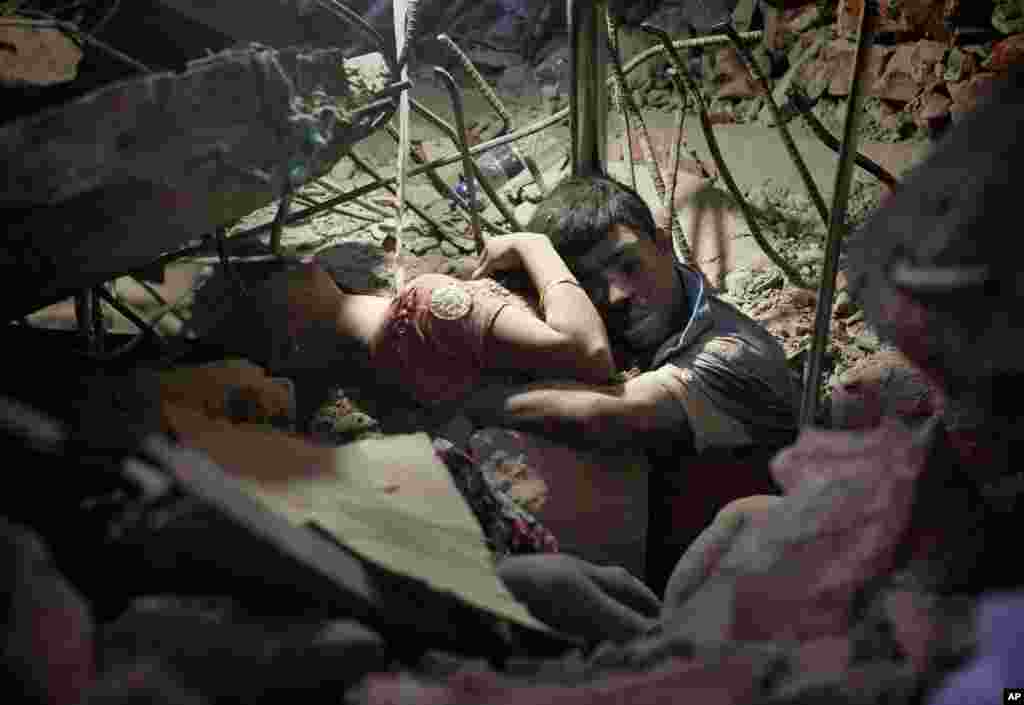 Seorang pria memeluk seorang perempuan setelah gedung pabrik garmen Rana Plaza roboh di Savar, dekat Dhaka, Bhangladesh, menewaskan lebih dari 1.100 orang (25/4). (AP/Suman Paul)