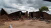 Victims of mob attacks sitting outisde their demolished houses on suspicion that they are withholding rains.